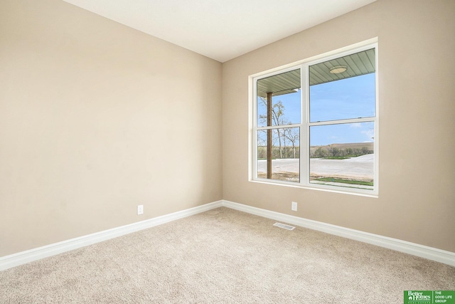 empty room featuring visible vents, carpet flooring, and baseboards