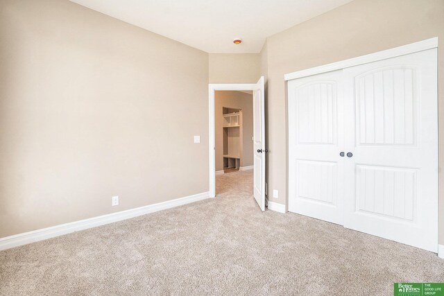 unfurnished bedroom with light colored carpet, baseboards, and a closet