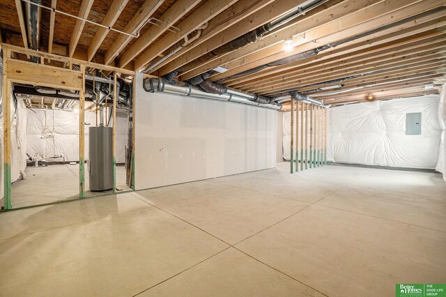unfinished below grade area with electric panel and water heater