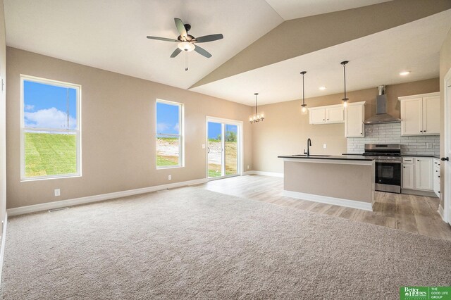 kitchen featuring open floor plan, stainless steel electric stove, dark countertops, and wall chimney exhaust hood