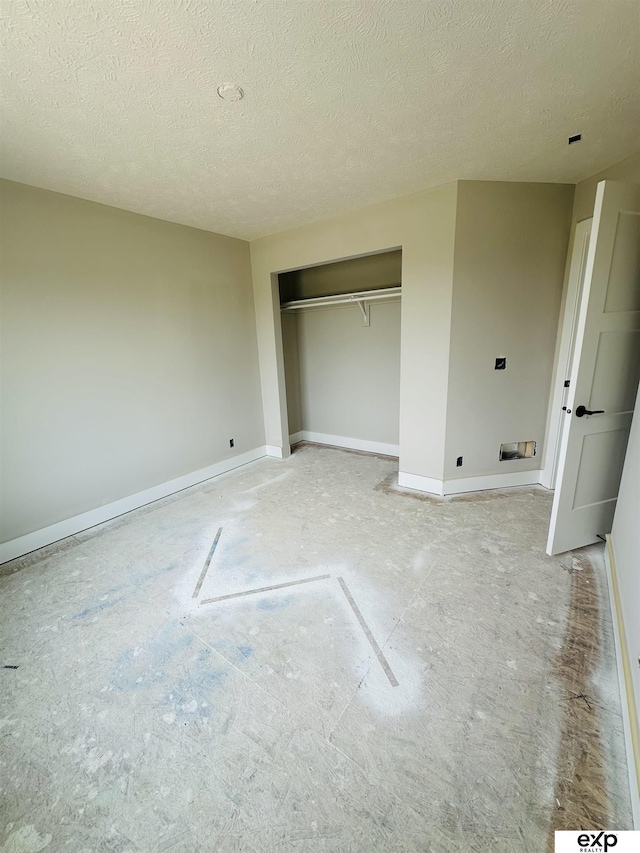 unfurnished bedroom with baseboards, a textured ceiling, and a closet