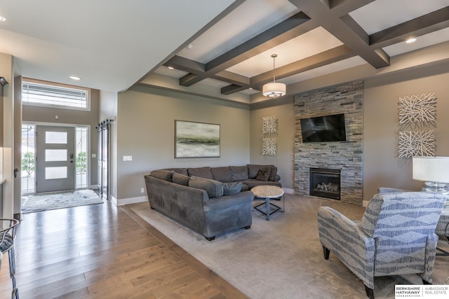 living area with a fireplace, coffered ceiling, wood finished floors, and baseboards