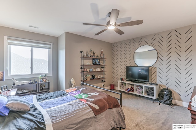 bedroom featuring wallpapered walls, carpet, visible vents, a ceiling fan, and an accent wall