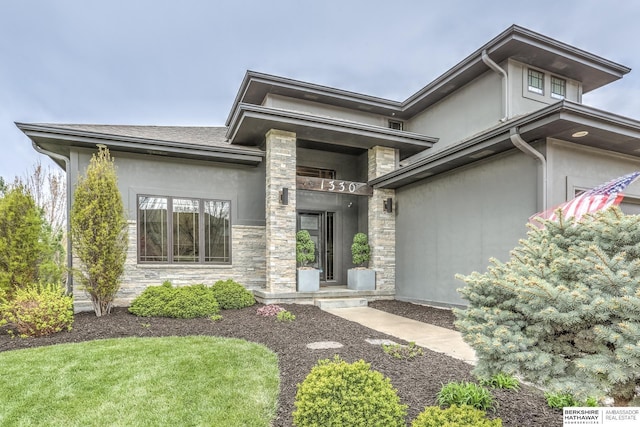 prairie-style home featuring stucco siding and stone siding