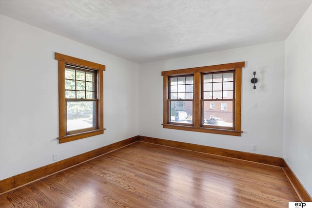 spare room with wood finished floors and baseboards