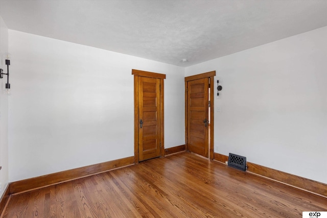 unfurnished room featuring baseboards and wood finished floors