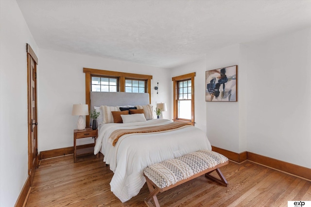 bedroom featuring baseboards and light wood-style flooring