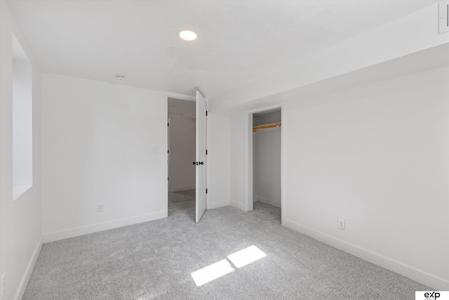 unfurnished bedroom featuring carpet flooring, baseboards, recessed lighting, and a closet