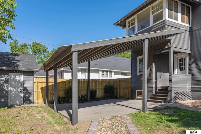 view of patio featuring fence and an outdoor structure