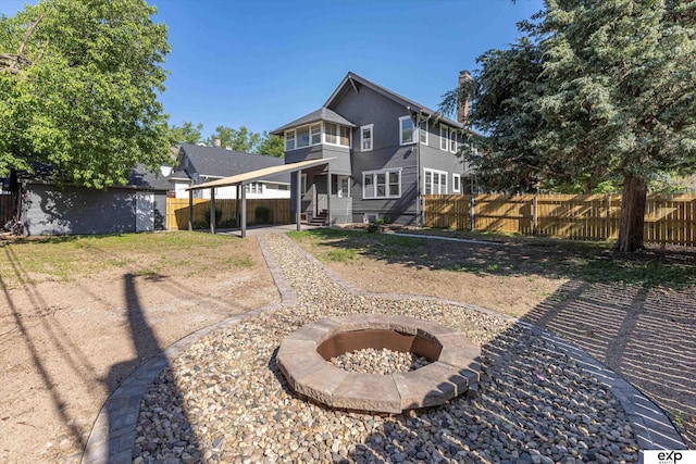 rear view of house featuring an outdoor fire pit and a chimney