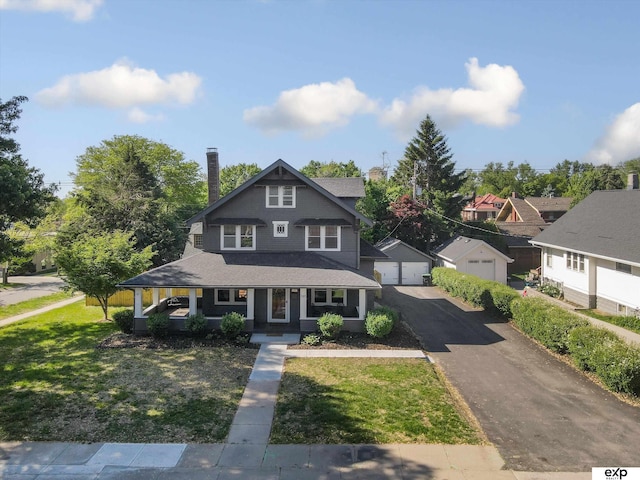 view of front of home with a porch, a front lawn, a garage, and a chimney