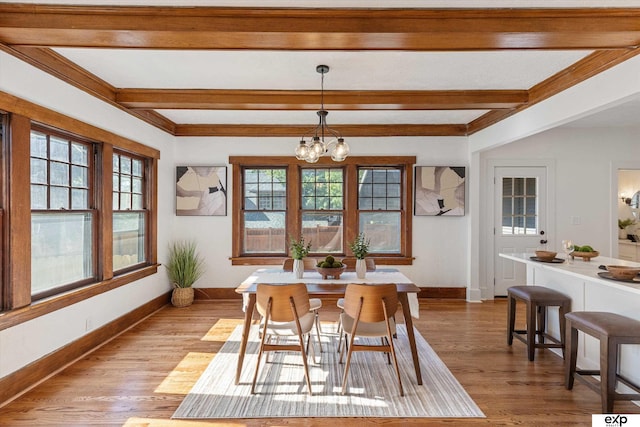 dining room with plenty of natural light, a chandelier, baseboards, and beamed ceiling