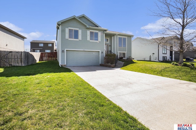 view of front facade featuring an attached garage, a front lawn, fence, and concrete driveway