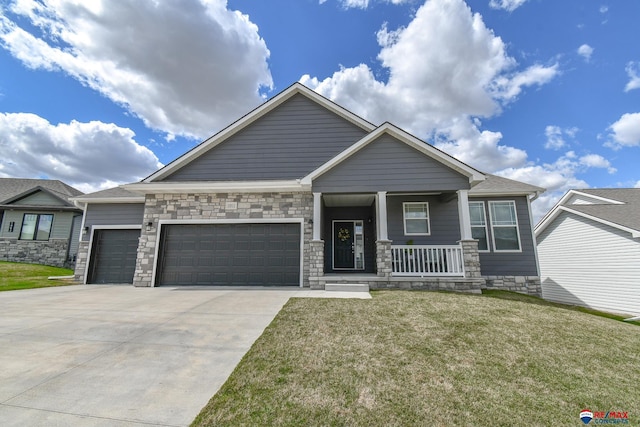 craftsman-style home with a garage, a front lawn, stone siding, a porch, and driveway