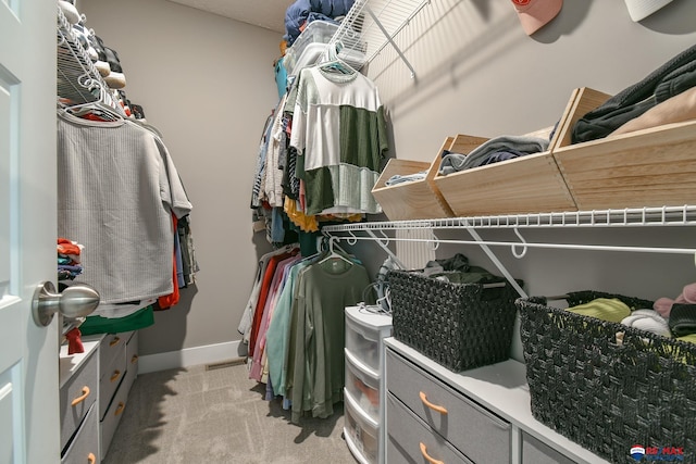 walk in closet featuring light colored carpet