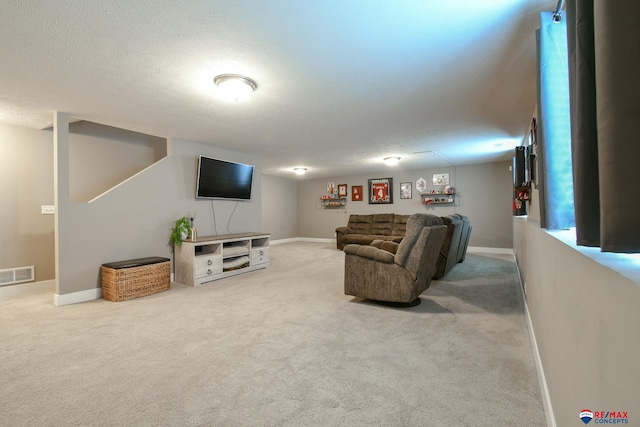 carpeted living room with a textured ceiling, baseboards, and visible vents