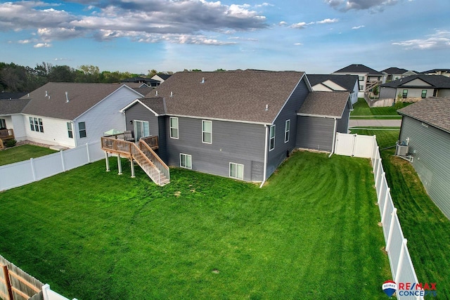 rear view of house featuring a wooden deck, stairs, a fenced backyard, and a residential view