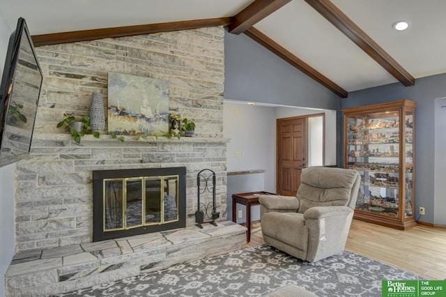 living room featuring wood finished floors, vaulted ceiling with beams, a fireplace, baseboards, and recessed lighting