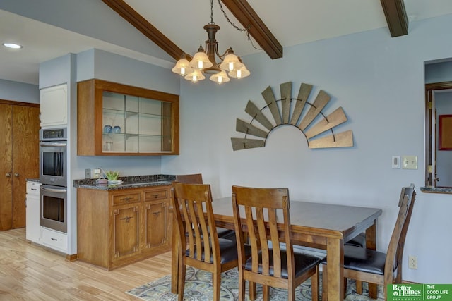 dining room featuring beamed ceiling, light wood-type flooring, and an inviting chandelier