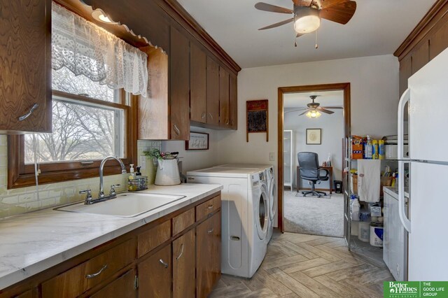 clothes washing area featuring cabinet space, independent washer and dryer, ceiling fan, and a sink