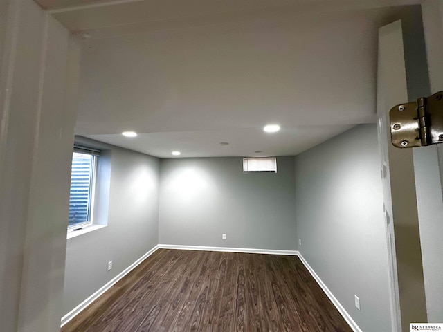 basement with baseboards, dark wood-style floors, and recessed lighting