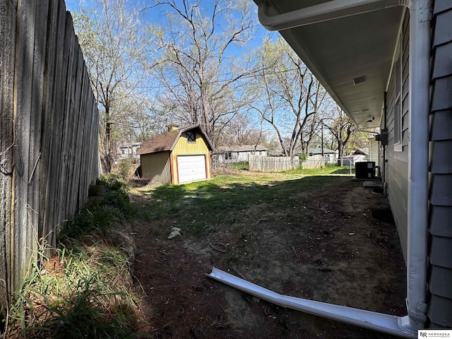 view of yard featuring fence, an outbuilding, and a garage