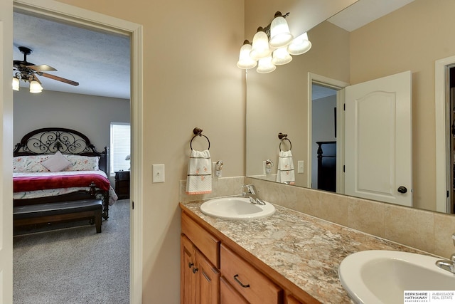 ensuite bathroom featuring a ceiling fan, a sink, double vanity, and connected bathroom