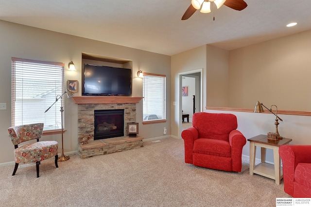 living room featuring a fireplace, carpet floors, ceiling fan, and plenty of natural light