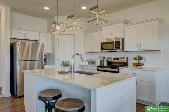 kitchen featuring white cabinets, dark wood-style floors, stainless steel appliances, and a sink