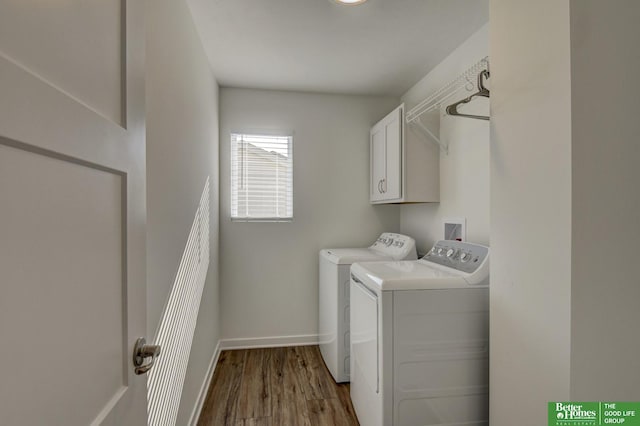 laundry area with washing machine and clothes dryer, cabinet space, wood finished floors, and baseboards