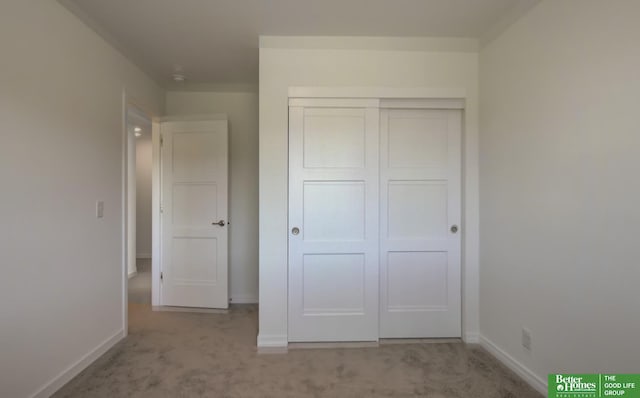 unfurnished bedroom with baseboards, carpet, and a closet