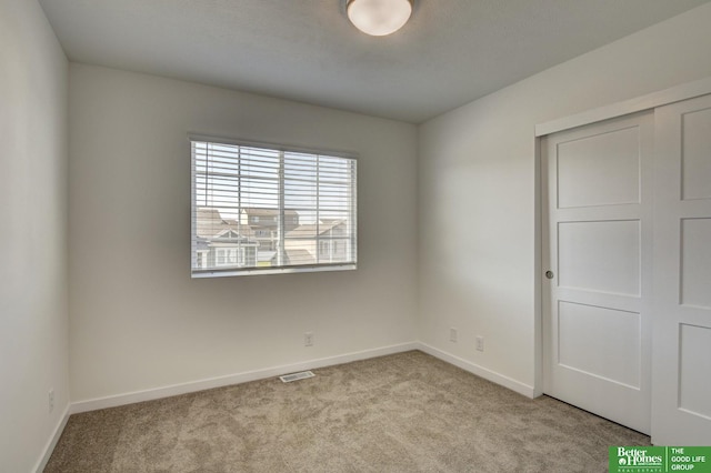 unfurnished bedroom with a closet, visible vents, baseboards, and light carpet