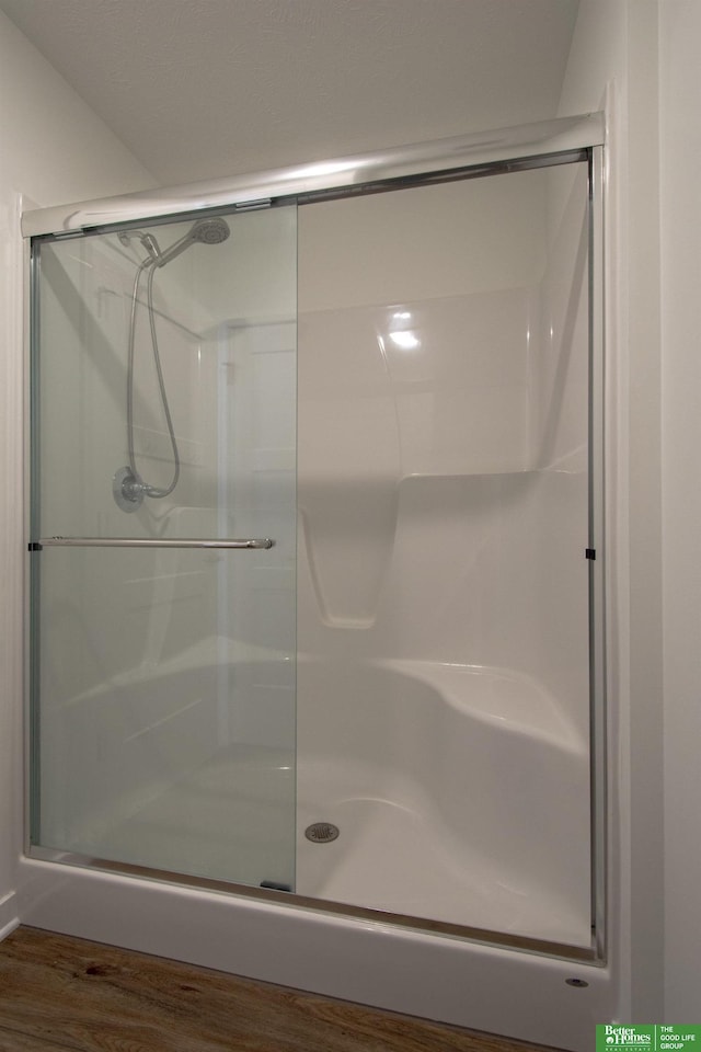 full bath with wood finished floors and a stall shower