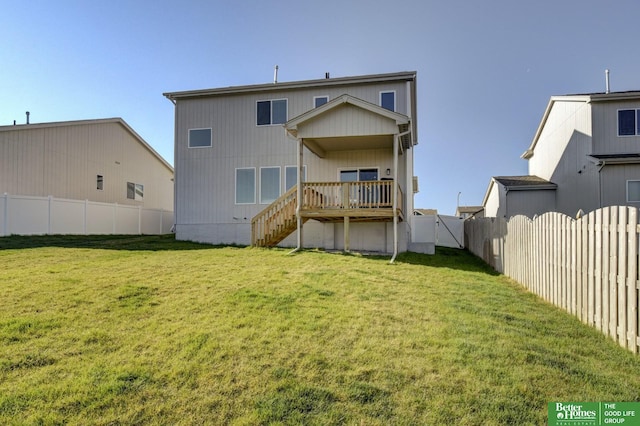 back of property featuring a fenced backyard, a wooden deck, a yard, and stairs