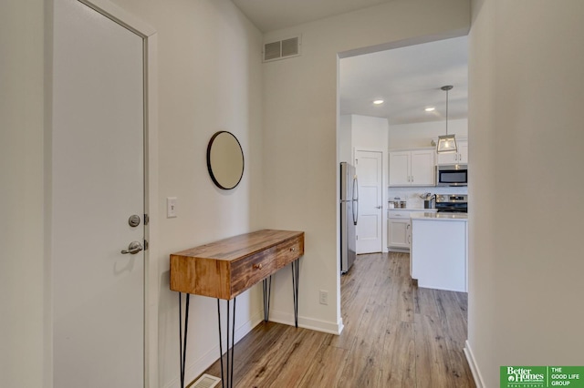 entryway with recessed lighting, light wood-style floors, visible vents, and baseboards