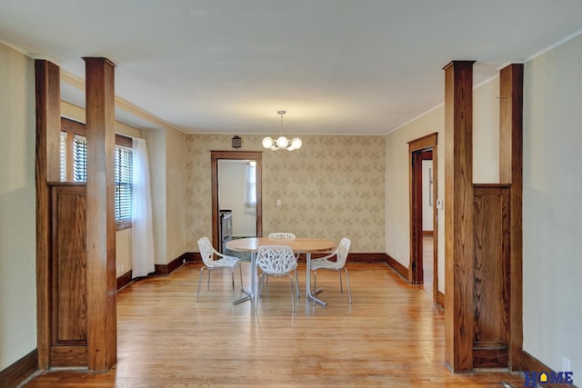 dining area featuring light wood-type flooring, baseboards, a chandelier, and ornamental molding