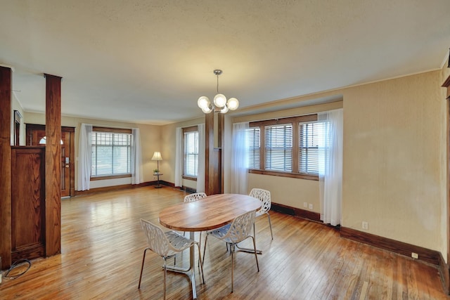 dining room featuring baseboards, light wood-type flooring, and an inviting chandelier
