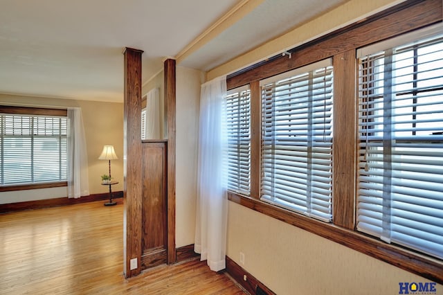 corridor featuring baseboards and wood finished floors