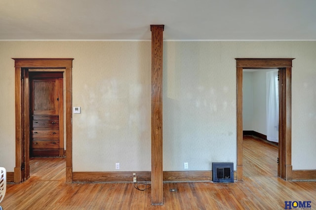 spare room featuring crown molding, wood finished floors, and visible vents