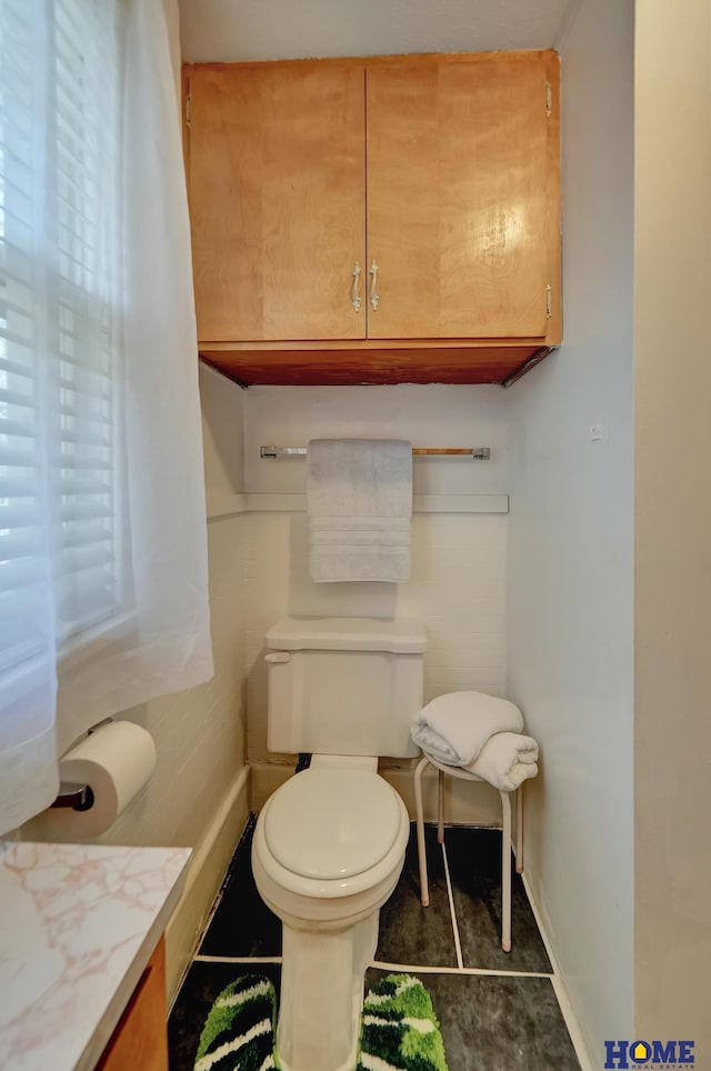 bathroom featuring baseboards, toilet, and vanity
