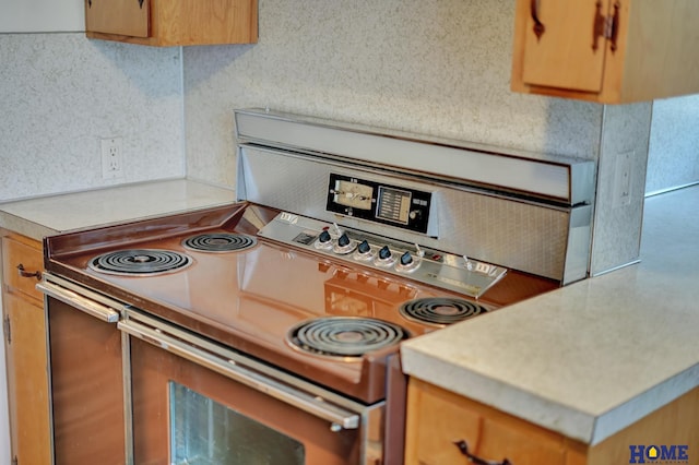 kitchen with stainless steel electric range oven and light countertops