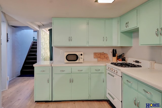 kitchen with light countertops, white appliances, light wood-style floors, and green cabinetry