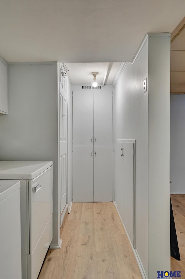 laundry area with washer and dryer and light wood finished floors