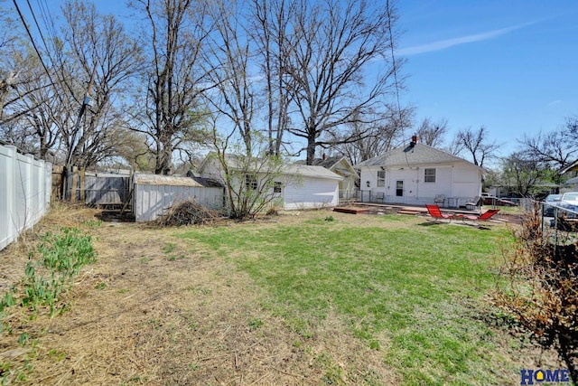 view of yard featuring a fenced backyard, a wooden deck, and an outbuilding