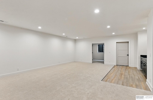 16951 Benjamin St, Bennington, NE 68007 - unfurnished living room featuring recessed lighting, baseboards, light carpet, and light wood finished floors