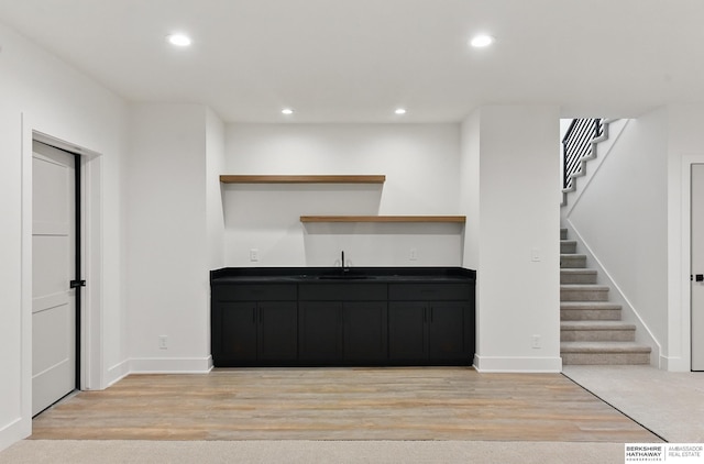 16951 Benjamin St, Bennington, NE 68007 - unfurnished living room with wet bar, stairs, light wood-type flooring, recessed lighting, and baseboards