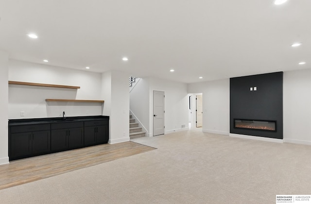 16951 Benjamin St, Bennington, NE 68007 - unfurnished living room featuring bar with sink, recessed lighting, light carpet, baseboards, and stairs