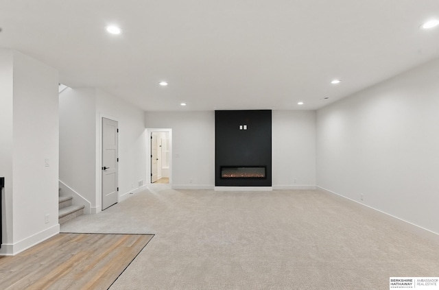 16951 Benjamin St, Bennington, NE 68007 - unfurnished living room featuring a fireplace, recessed lighting, stairs, light carpet, and baseboards