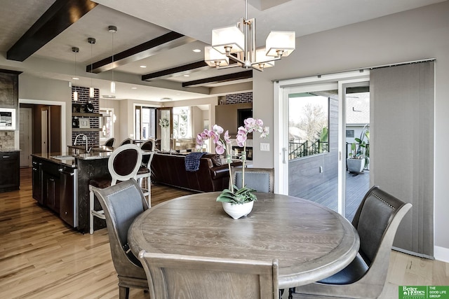 dining area featuring beamed ceiling, light wood finished floors, a notable chandelier, and recessed lighting