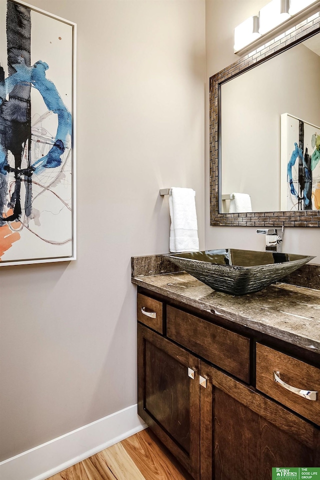 bathroom featuring wood finished floors, baseboards, and vanity